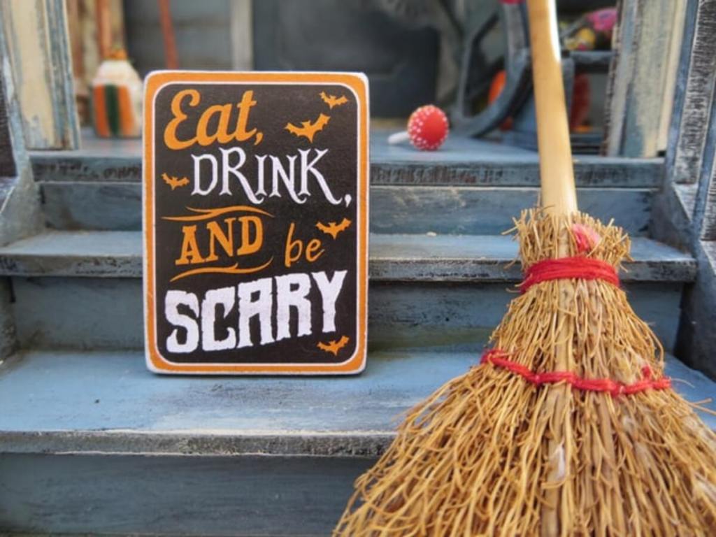 A signage with a broom outside of a pub.