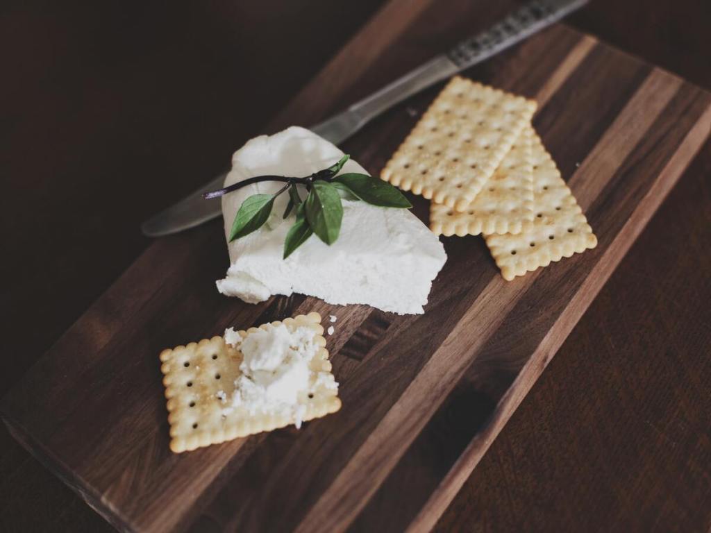 Cheese and crackers on a wooden board.