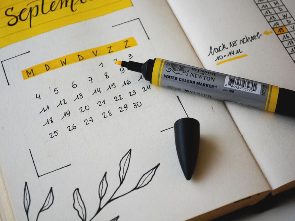 A planning calendar and a yellow marker pen.