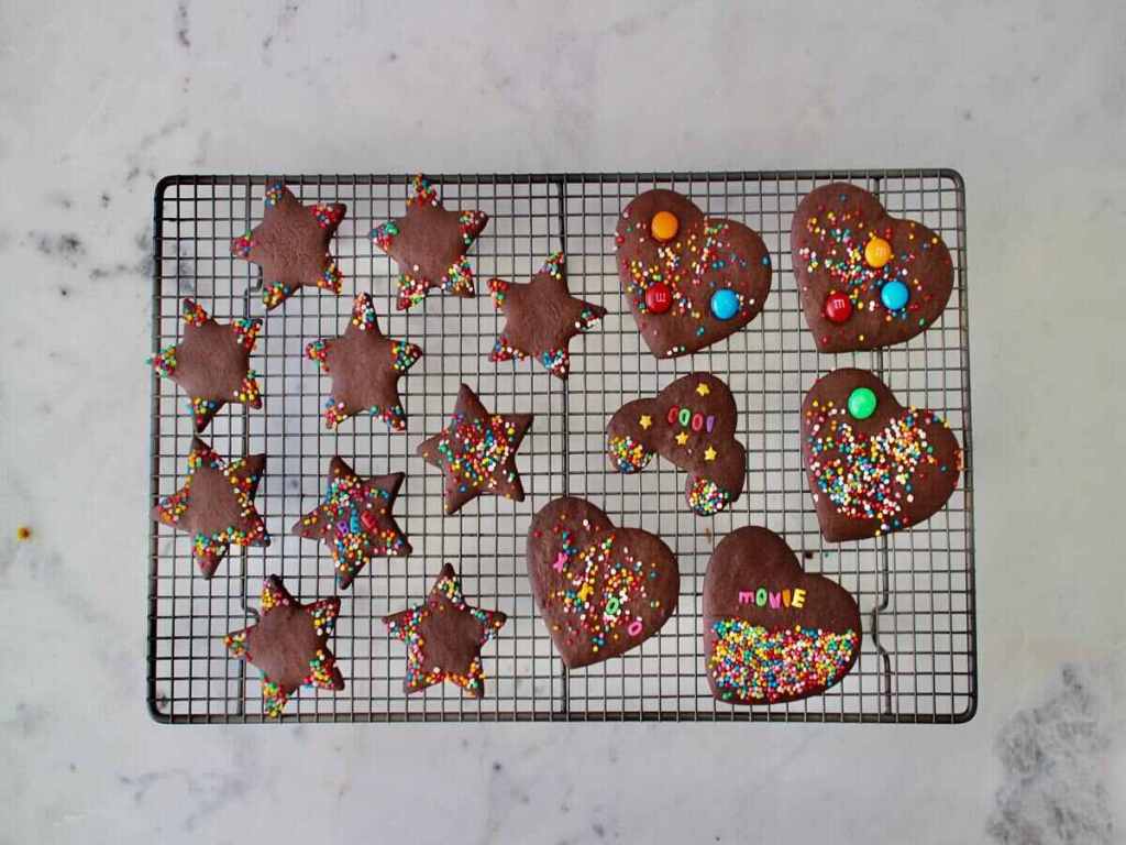 Chocolate coated cookies on a cooling rack.