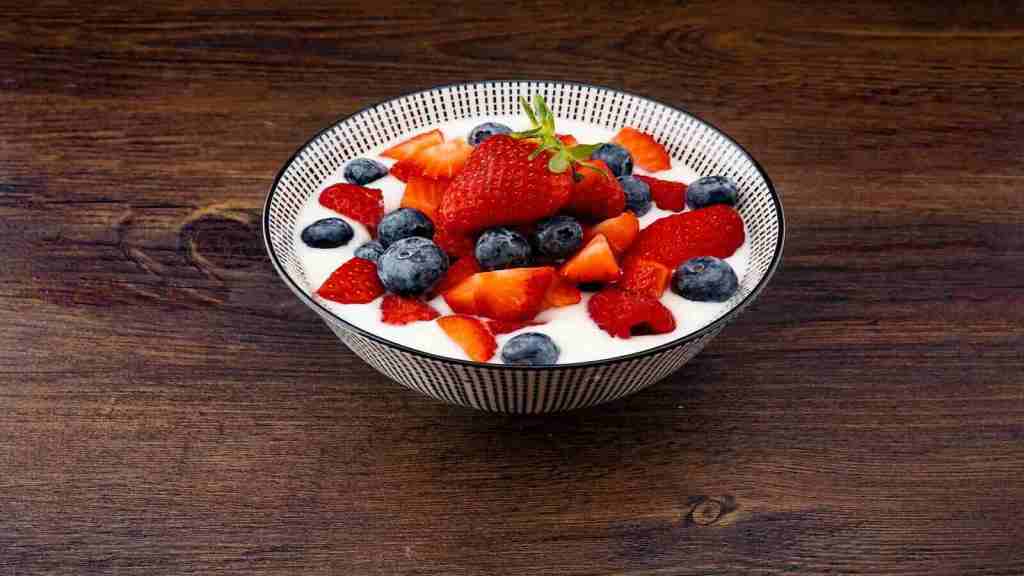 A bowl of milk kefir with fresh strawberries and blueberries. 