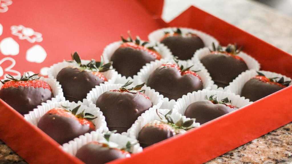 Chocolate-coated strawberries in a red box.