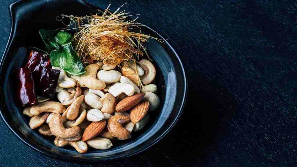 Nuts and seeds in a black bowl.