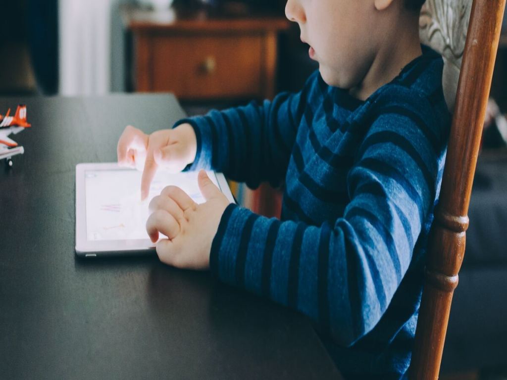 A little boy playing with a tablet.