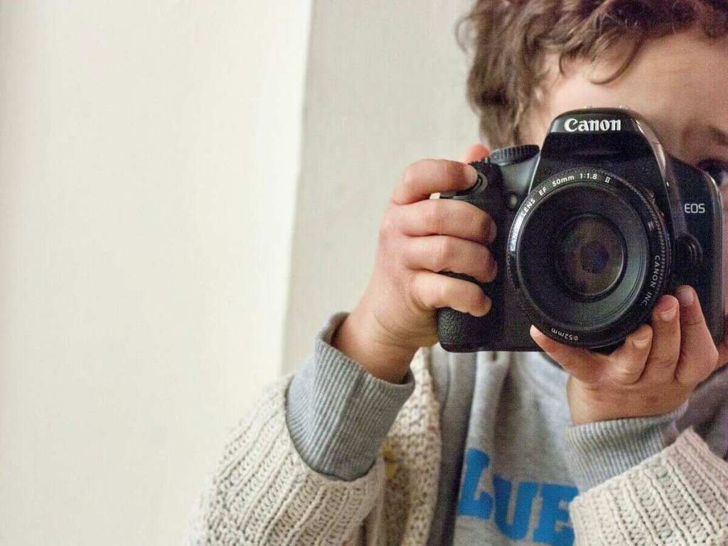A small boy holding a camera.