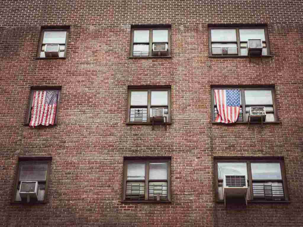 American flag on a window on a brick building.