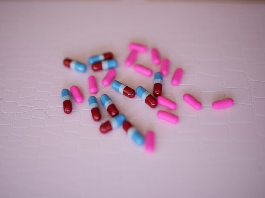 Multicolored capsules of medications on a white background.