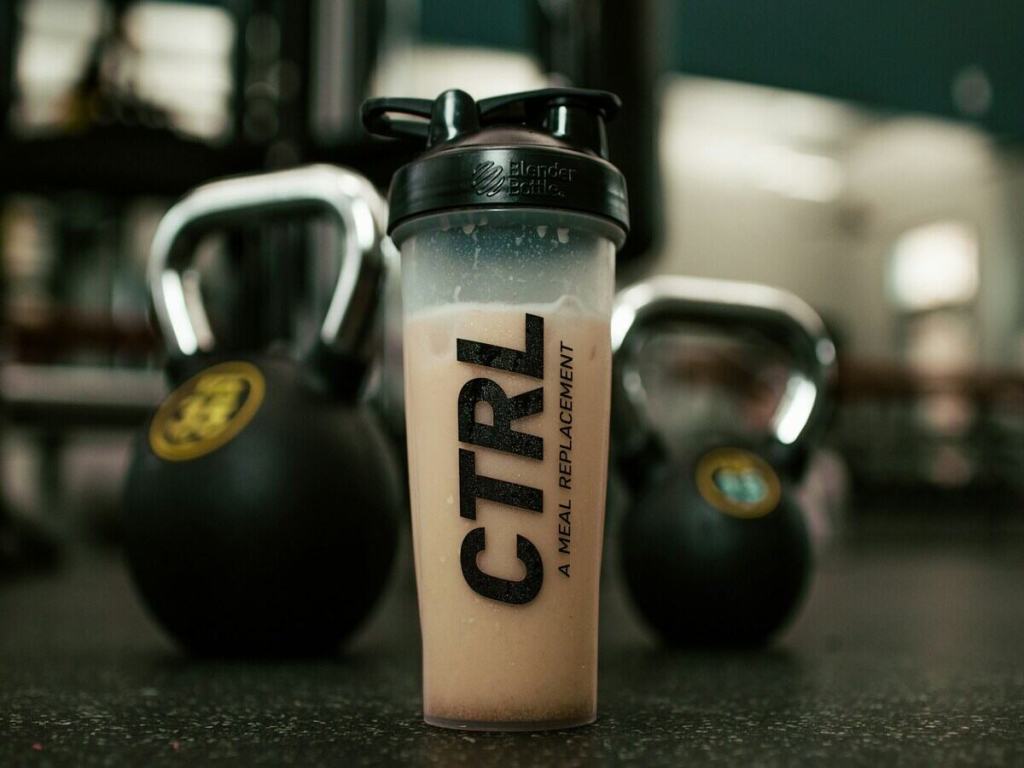 A protein shake with kettles in the gym.