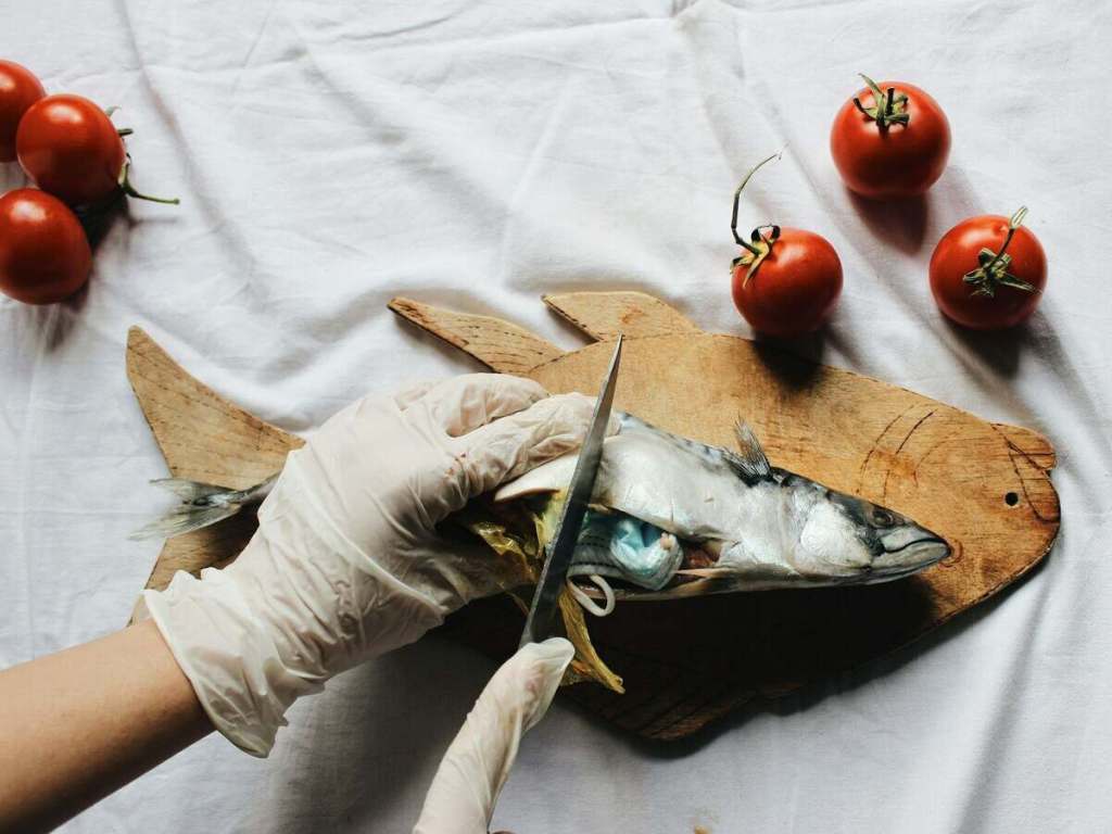 Cutting a fish on a cutting board.